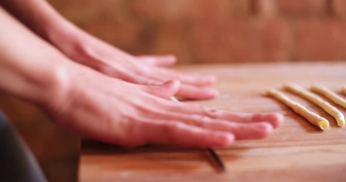 close up of young girl coocking traditional italian pasta fresca with hands flour baking pastry at home,  lady housewife cooking in cozy kitchen alone preparing food on a wooden table