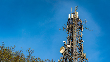 Shot of Communications tower hosting various antennas and dishes