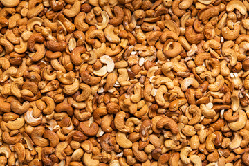 Delicious cashew nuts as background, top view. Many nuts