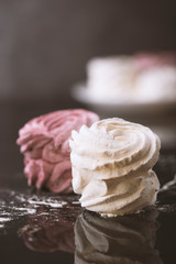 White and pink marshmallows shot on a dark background