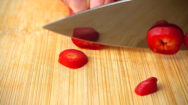 The cook cuts the capi pepper with a knife. Slow motion.
