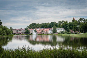 Fototapeta premium View of old town and small lake with fountain. Cityscape in summer rain. Talsi, Latvia.