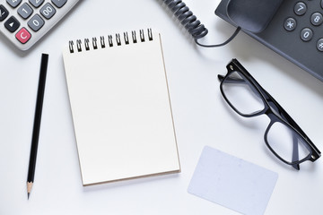 Top view office desk, Paper sheet for writing simple messages or memos with pencil, card, phone, glasses and calculator is elements.