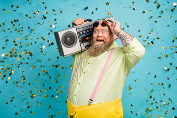 Portrait of his he nice attractive cheerful cheery funky bearded guy carrying boombox having fun...