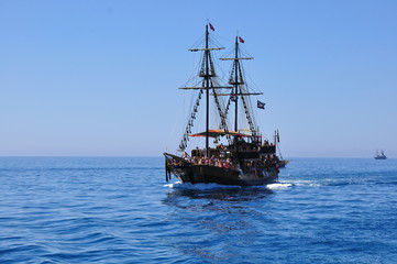 Fototapeta premium Statek z turystami na pełnym morzu pod błękitnym i czystym niebem. Miłe miejsce i czas na odpoczynek.