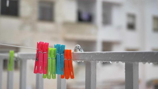 Pinzas de colgar ropa con patio interior bajo lluvia en c&aacute;mara lenta