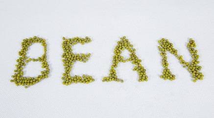 Green bean seed on white background, shaped B letter