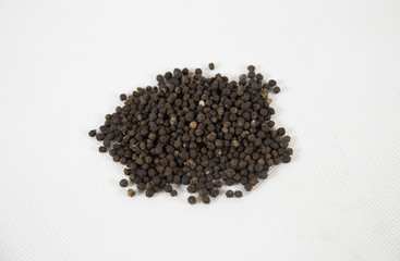 Black pepper corns on white background