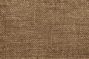 Burlap macro photo. The texture of the fibers and threads of coarse canvas. Seamless burlap texture.