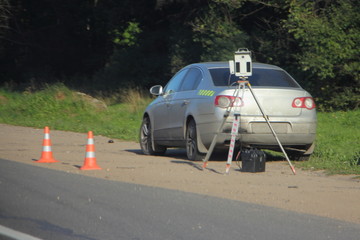 Speedcam on a tripod near car on roadside on forest background at Sunny summer day, mobile outdoor...