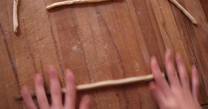 close up of young girl coocking traditional italian pasta fresca with hands flour baking pastry at home,  lady housewife cooking in cozy kitchen alone preparing food on a wooden table
