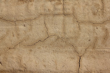 Rough clay plastered wall with cracks - texture for background