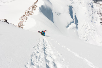 Group of mountaineers climbing a very steep slope of snow near the summit of Liskamm, between Italian and Swiss Alps