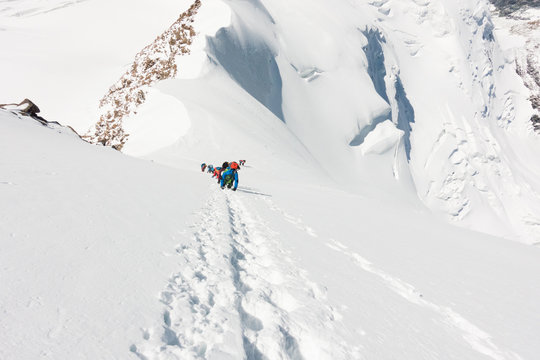 Group Of Mountaineers Climbing A Very Steep Slope Of Snow Near The Summit Of Liskamm, Between Italian And Swiss Alps