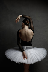 Young beautiful ballet dancer is posing in studio