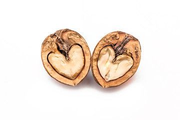 Two halves of a walnut in the shape of a heart isolated on a white background