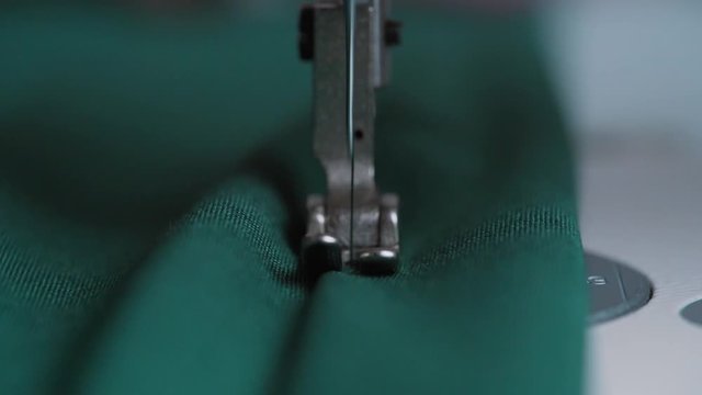 Closeup the sewing machine and item of clothing, old sewing machine,vintage style. Steel needle with looper and presser foot close-up