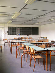 Salle de classe rétro avec chaises, tables et tableau noir vide