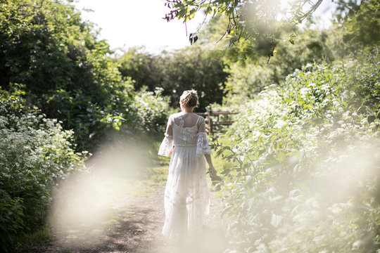 Woman walking through cow parsley in the countryside