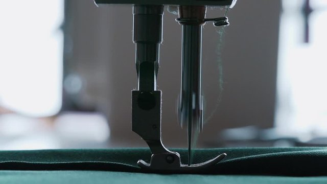 Closeup the sewing machine and item of clothing, old sewing machine,vintage style. Steel needle with looper and presser foot close-up