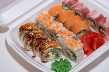 Japanese sushi rolls in a white delivery box.     