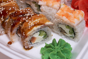 Japanese sushi rolls in a white delivery box.     