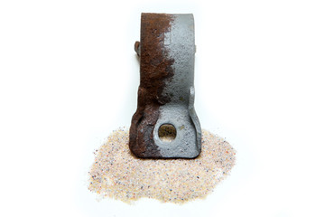 The overgrown rusty cast iron part partly sand blasted together with sand isolated in a white background. 