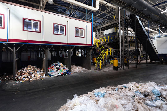 GRODNO, BELARUS - OCTOBER 2018: manual waste sorting department at modern waste plant with conveyor transports garbage inside drum filter sieve with trommel for sorting garbage into fractions.
