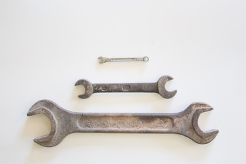 Old rusty wrench on a white and metal background. several wrenches of different sizes. Card with copy space for text