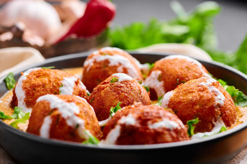 Malai Kofta Curry in black bowl. Malai Kofta is indian cuisine dish with potato and paneer cheese deep fried balls in onion tomato gravy with spices. Indian Food. Close Up