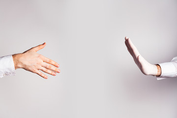 Men's hand without a glove and hand in a glove without a handshake