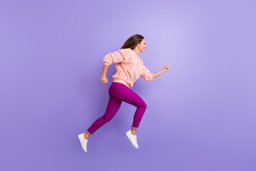 Full length profile photo of active lady jumping high up rushing speed shopping sale black friday wear casual warm fluffy sweater pants shoes isolated purple color background