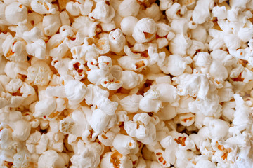 Background of yellow salted popcorn closeup. Food texture