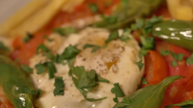 Mokli tunisien is a North African Jewish origin dish of eggs poached in a sauce of tomatoes, chili peppers, and onions, often spiced with cumin.