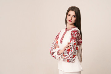 Young beautiful brunette girl wearing gorgeous ethnic style embroidered shirt, modern derivative...
