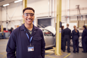 Portrait Of Male Student With Safety Glasses Studying For Auto Mechanic Apprenticeship At College - obrazy, fototapety, plakaty