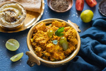 Oriental food - Indian paneer sabji with chapati and sauce. indian cuisine. Indian Curry in copper brass with ingredients in blue background close-up, Set of Indian food.