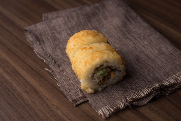 delicioso sushi o comida oriental en fondo de tela y madera