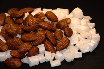 Coconut with almonds on a black background