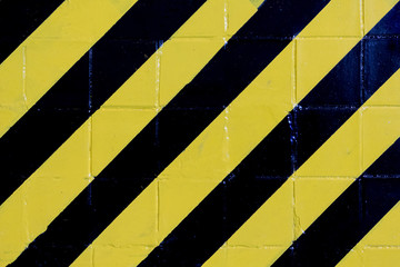 Black and yellow lines on wall. Danger sign