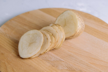 Sliced potato slices on a cutting kitchen board