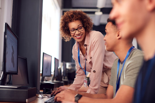 Group Of College Students With Tutor Studying Computer Design Sitting At Monitors In Classroom