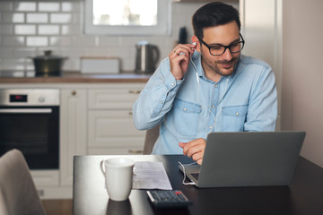 Man putting headphones for an online meeting.