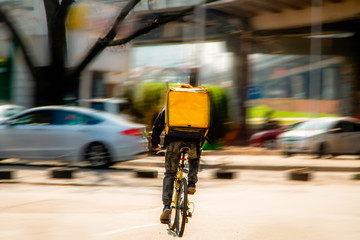 Courier on a bicycle to pick up and deliver an order from the fast food restaurant. Photo in...