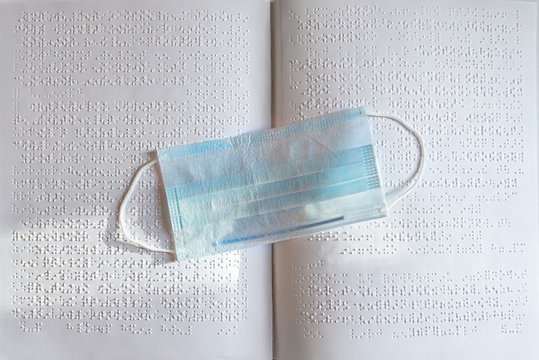 book in Braille with a mask from COVID-19