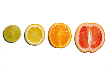 Slices and halves of lemon, lime, orange and grapefruit on a white background. Multiple kinds of citric together.  