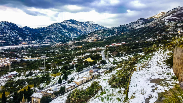 Colline innevate in un insolito e suggestivo giorno siciliano. Colori caldi, cimitero coperto di neve, erba sparsa e clima magico