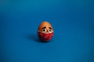 egg with eyes and in a red mask on a blue background
