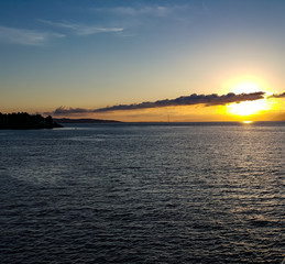 Tramonto sullo stretto di Messina, ricco dei caldi colori del sole e della luce che abbaglia il mare.