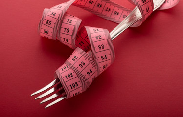 fork wrapped in a centimeter. weight loss symbol